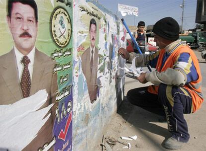 Un operario retira un carteles electorales en Bagdad.
