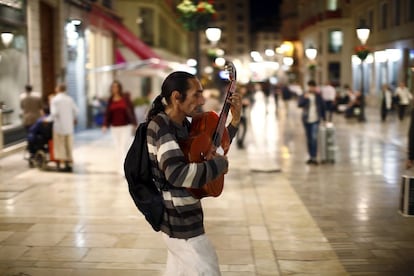 A man plays his guitar as he asks for alms at Marques de Larios street in downtown Malaga, southern Spain, October 22, 2015. Spain's unemployment rate has fallen to its lowest level in over four years and is now lower than when Prime Minister Mariano Rajoy took office, potentially boosting his chances in an election less than two months away. Frustration over an enduring jobs crisis will weigh on the Dec. 20 vote, with many Spaniards divided over whether their prospects are improving after a double-dip recession that sent unemployment soaring to nearly 27 percent in 2013. REUTERS/Jon Nazca