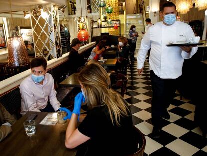 Varias personas desayunan en el restaurante Núria de la Rambla de Barcelona.