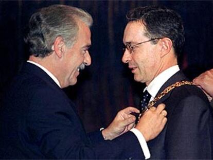 El presidente saliente, Andrés Pastrana (izq.) condecora a su sucesor, Alvaro Uribe (der.).