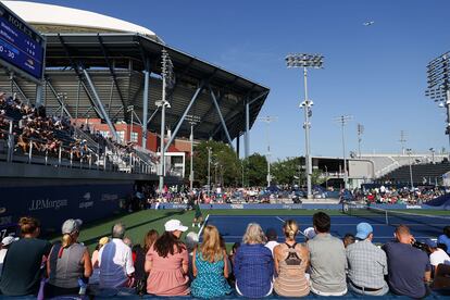 Aficionados presencian un partido en la primera jornada del US Open, con la Pista Arthur Ashe al fondo.