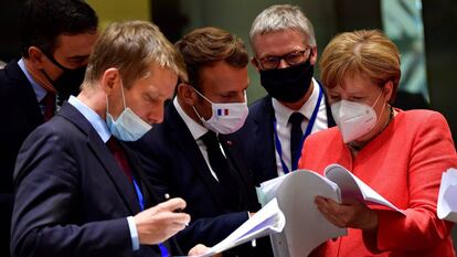 Pedro Sánchez, Emmanuel Macron, y Angela Merkel examinan documentos durante la cumbre de la UE en Bruselas.