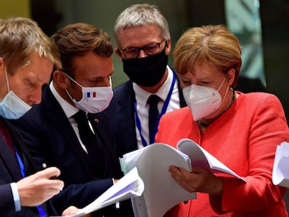 Pedro Sánchez, Emmanuel Macron, y Angela Merkel examinan documentos durante la cumbre de la UE en Bruselas.