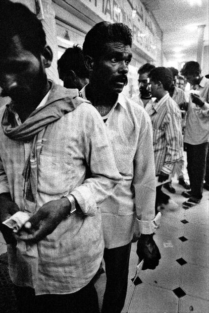 Migrantes de Bangladesh en una oficina de correos en Dubai. Envían cartas y dinero a casa. Imagen de 'The Tide Will Turn', publicado por Steidl. 