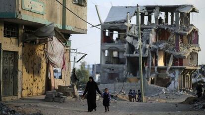 Uma mãe e seu filho, nas ruínas de Gaza.