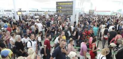 Colas de pasajeros para pasar el control de seguridad en el aeropuerto de El Prat, en Barcelona.