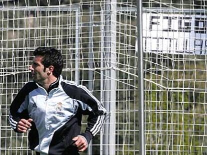 Figo, durante el entrenamiento de ayer, ante una pancarta de apoyo.