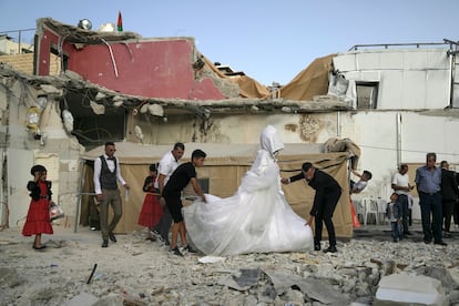 Una pareja palestina comienza su ceremonia de boda desde las ruinas de su casa en el barrio de Silwan, en el este de Jerusalén, el pasado sábado. El ejército de Israel ha intensificado esta última semana las demoliciones en el sur de Cisjordania tras el fallo del Supremo israelí que declara terreno militar las tierras de familias beduinas. Implica una de las mayores expulsiones de población desde el inicio de la ocupación hace 55 años.