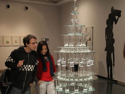 Dos jóvenes observan la obra <i>La custodia del cubata </i>en Córdoba.
