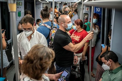 Decenas de pasajeros, en agosto de 2020 en los vagones de uno de los trenes que recorre la linea 10 del metro de Madrid.