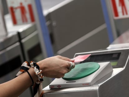 Una mujer pasa su billete en el torno de la estación Plaza de España del metro de Madrid, en julio de 2020.