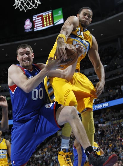 Hawes, de los 76ers, lucha por el rebote con McGee, de los Nuggets.