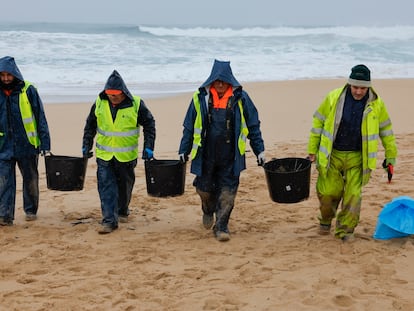 Unos operarios retiran los 'pellets' de plástico, este martes en la playa de O Vilar, en el parque natural de Corrubedo, en A Coruña.
