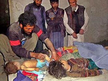 Un grupo de hombres vela los cadáveres de cuatro de los niños muertos durante los bombardeos.