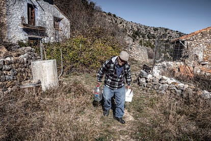 Martín Colomer camina por las calles de la Estrella, invadidas por la maleza, cargando agua y comida para sus animales. 