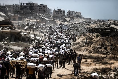 Palestinos trasladan harina recibida en el punto de distribución de ayuda humanitaria en el cruce fronterizo de Zikim, en la franja de Gaza, el viernes.