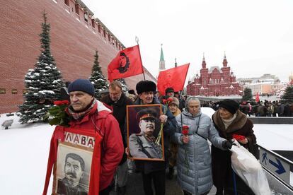 Varios comunistas rusos sostienen retratos de Joseph Stalin mientras van a dejar flores a su tumba en conmemoración del 137 aniversario de su nacimiento, en Moscú (Rusia).