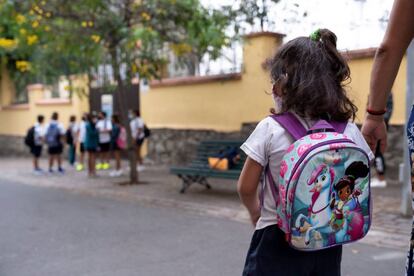 Una niña acude a clase al colegio Isabel la Católica, en Santa Cruz de Tenerife de la mano de su madre.
