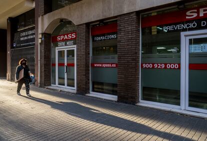 Una persona pasa frente a una de las sedes del laboratorio inspeccionado por el departamento de Salud y los agentes de la Guardia Urbana en Barcelona.