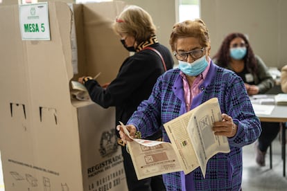 Una mujer se prepara para depositar su voto en una urna en un colegio de votación en Bogotá Colombia, el 13 de marzo de 2022.