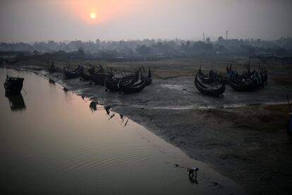 Un refugiado Rohingya trabaja en el agua al amanecer junto a unos barcos de pesca en el campo de refugiados de Shamlapur Rohingya, en Cox's Bazar (Bangladesh)