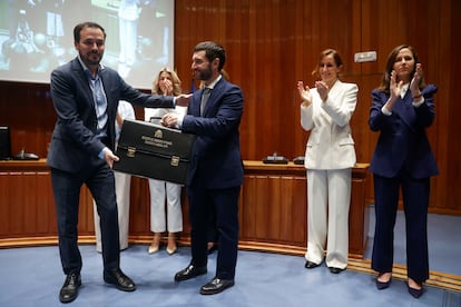 El nuevo ministro de Derechos Sociales, Consumo y Agenda 2030, Pablo Bustinduy (centro), recibe el maletín del exministro saliente de Consumo, Alberto Garzón (a la izquierda).