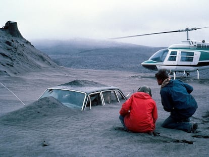 Geólogos observan un coche semienterrado por la ceniza de la erupción del monte Santa Helena (noroeste de EE UU), en 1980.