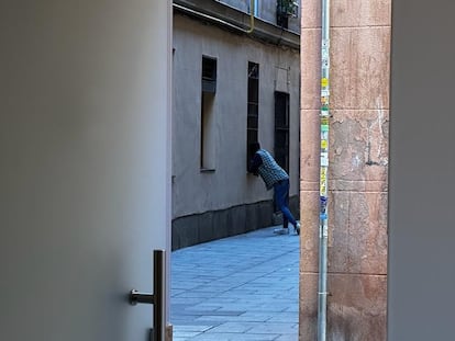 Un hombre apoyado en la ventana por la que presuntamente se dispensa droga.