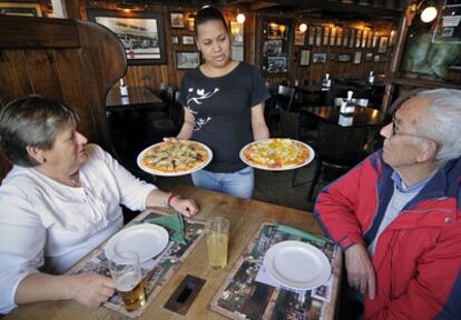 Una camarera sirve a dos clientes en el restaurante Pizzbur en Covas (Viveiro).