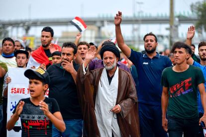En un discurso anoche a la nación, el primer ministro de Irak, Adil Abdelmahdi, prometió, poco después de que comenzasen a congregarse manifestantes en el centro de Bagdad, ya alrededor de la medianoche, que la semana que viene remodelará su Gabinete. En la imagen, un clérigo chií participa en un marcha en la ciudad sagrada de Najaf.