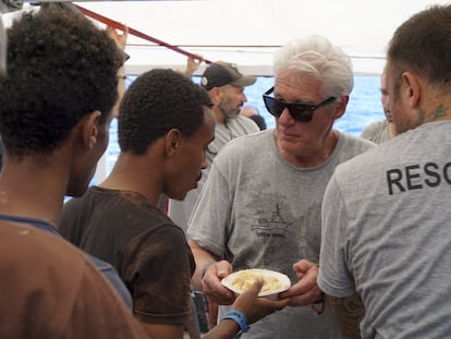 El actor Richerd Gere ayuda a servir comida.
