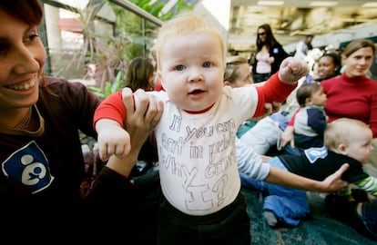 Lukovic holds son Julien during protest at Fort Lauderdale airport