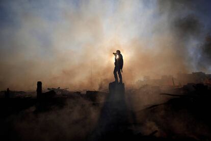 Un fotógrafo toma imágenes de un incendio en el barrio de Paranoa en Brasilia (Brasil).