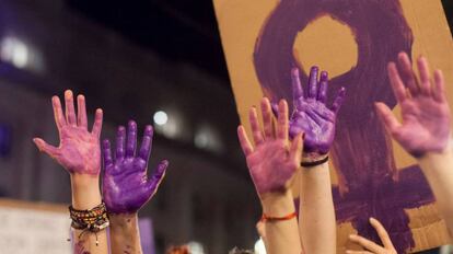 Varias manos pintadas de morado en una manifestación del 8 de marzo.