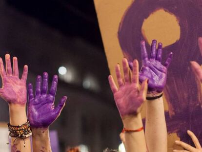 Varias manos pintadas de morado en una manifestación del 8 de marzo.