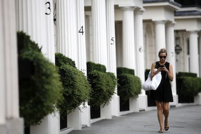 Una mujer camina por una zona residencial de lujo en Londres.