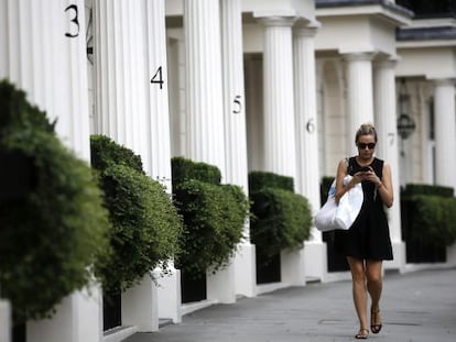 Mulher caminha por uma zona residencial de luxo em Londres.