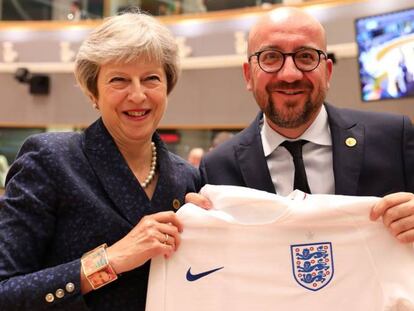 El primer ministro belga, Charles Michel, recibe de Theresa May la camiseta de la selección inglesa en la cumbre europea. 