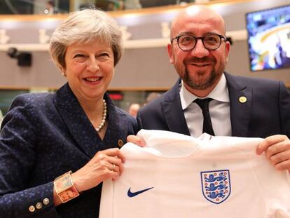 El primer ministro belga, Charles Michel, recibe de Theresa May la camiseta de la selección inglesa en la cumbre europea. 