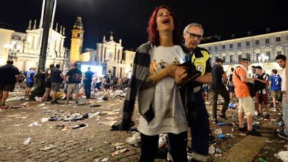 Uma torcedora da Juventus é retirada da Piazza San Carlos, no centro de Turim.