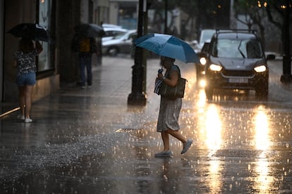 Una mujer cruza la calle en Castellón bajo una intensa lluvia, este miércoles.