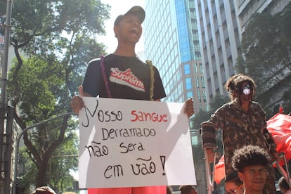 Jovem mostra cartaz durante ato desta segunda. 