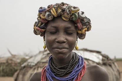 Una joven dassanach posa con los ojos cerrados durante la realización del proyecto 'Ape dumma - Open your eyes' en el valle del río Omo, en la zona Debut Omo. La tribu dassanach, también conocida como marille o geleba, habita partes de Kenia, Sudan y Etiopía. La aculturación ha hecho que las mujeres daasanach incluyan entre sus adornos objetos tan peculiares como los tocados de chapas de botella.