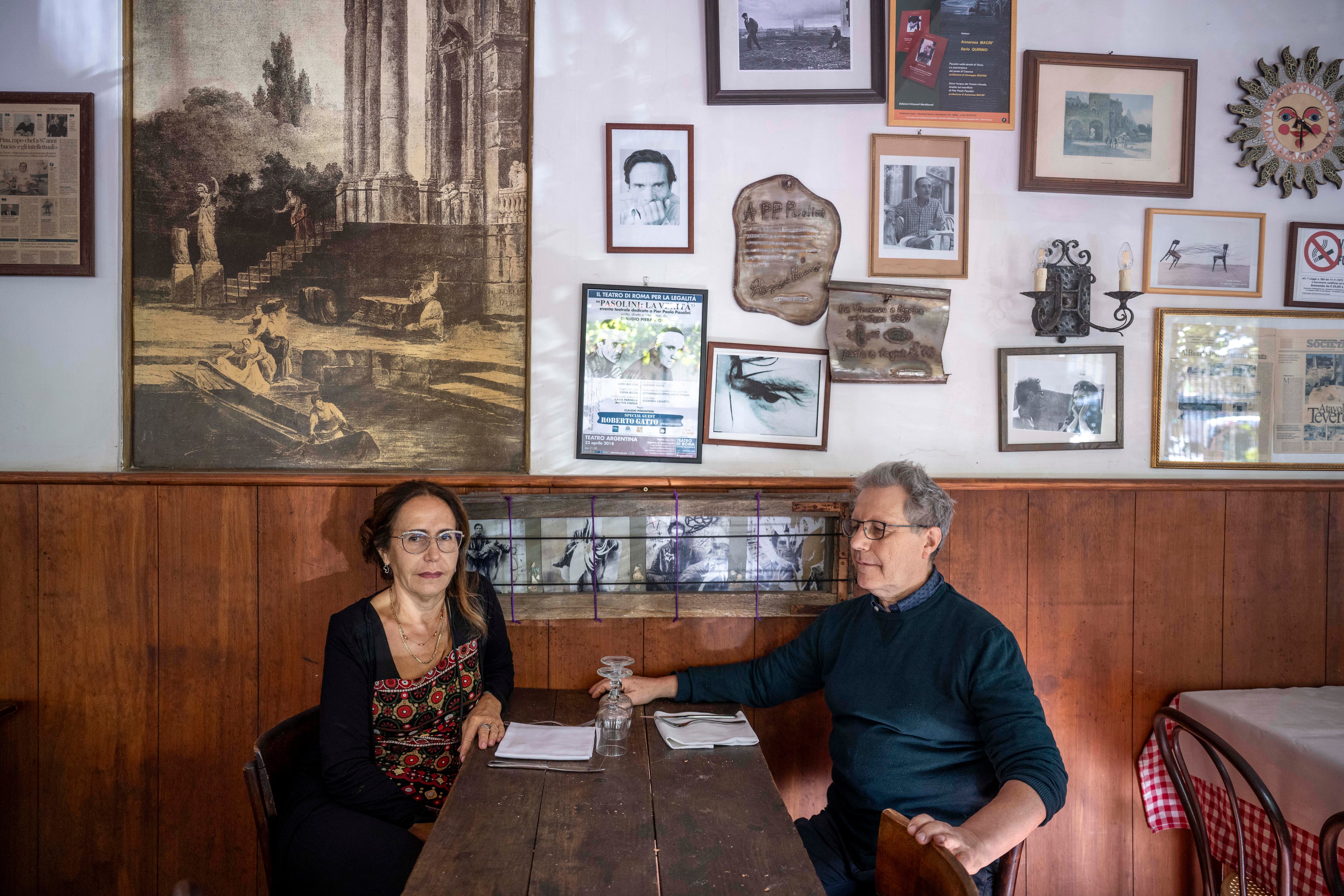 Los dueños del restaurante 'Il Biondo Tevere', los hermanos Roberto y Laura Panzeroni, en la mesa donde cenaron Pasolini y Pelosi la noche en que el escritor fue asesinado.