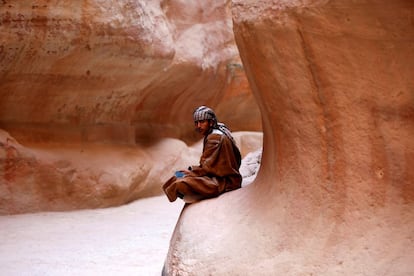 Joven beduino sentado en el Siq en la antigua ciudad de Petra (Jordania).