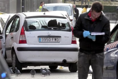 Un policía de paisano, junto al Citroën C-3 tiroteado por los agentes locales de Getafe en la calle Vara del Rey.