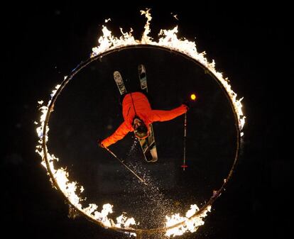 Un esquiador salta a través de un anillo de fuego durante un espectáculo de fuego y hielo en la montaña Whistler en Whistler, British Colombia.