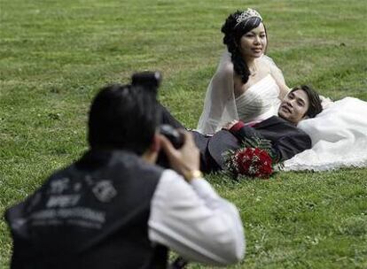 Una pareja de novios chinos posa para el reportaje fotográfico de su boda en Madrid.