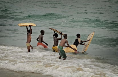 Ni&ntilde;os jugando con tablas en la playa de Guet Ndar.