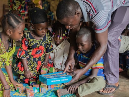 Un grupo de niños y su maestro juegan en el jardín de infancia en el municipio de Péréré, en Benín.